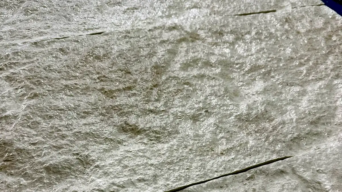 Textura de uma placa cimentícia Art Cimento em branco, com relevo de pedra.